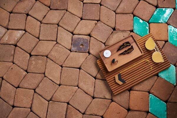 Baldosas cerámicas esmaltadas en verde agua contrastadas con baldosas de barro en tonos tierra
