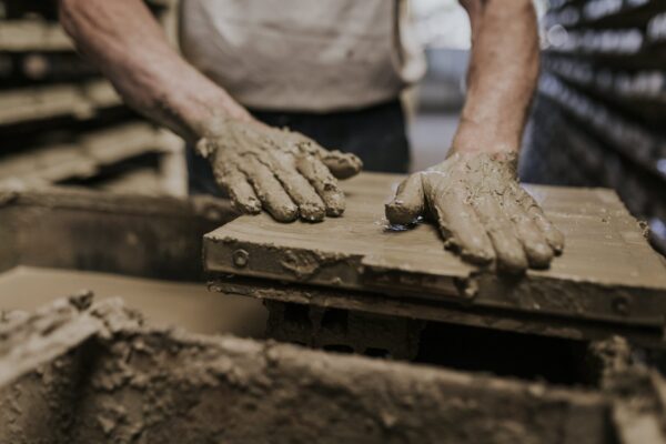 Neoartesanía. Plano de as manos de un hombre trabajando de manera artesanal el barro cocido desde una empresa sostenible
