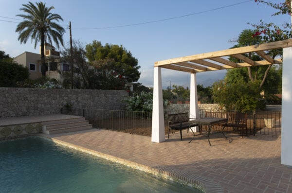 Piscina exterior con suelo de barro con baldosas en tonos tierra