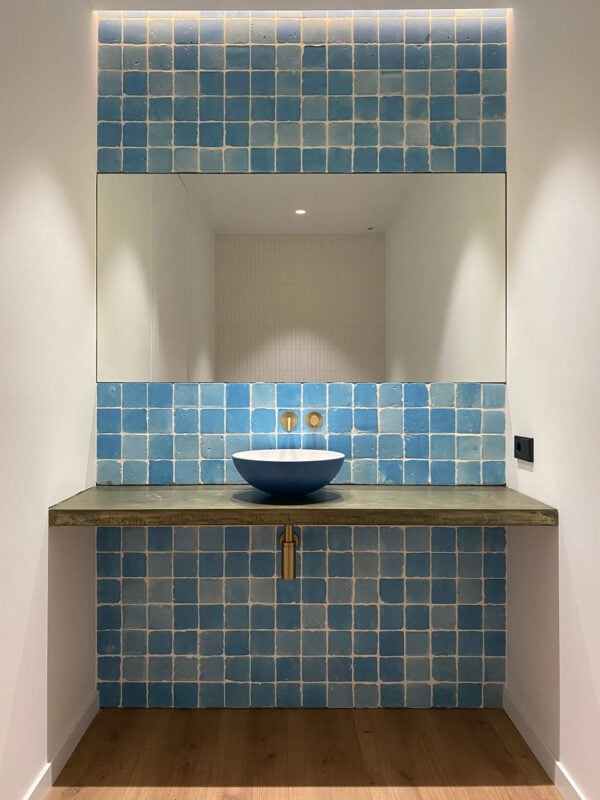 Baño con espejo y baldosa de barro azul